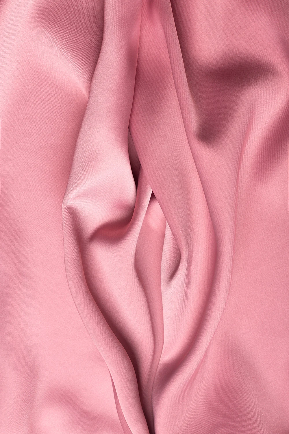 Draped pink fabric with soft folds and creases.